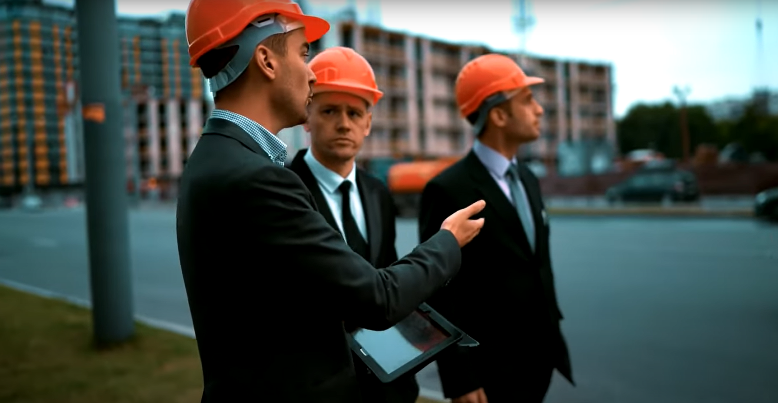 Workers wearing hard hats and safety vests at a construction site in Dayton, Ohio, discussing safety protocols related to workers' compensation.